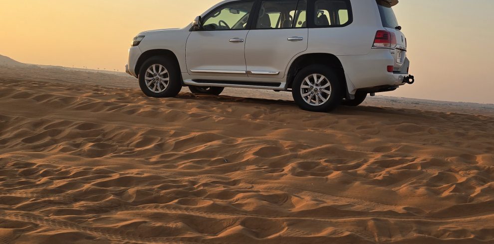 White SUV on sandy desert dunes